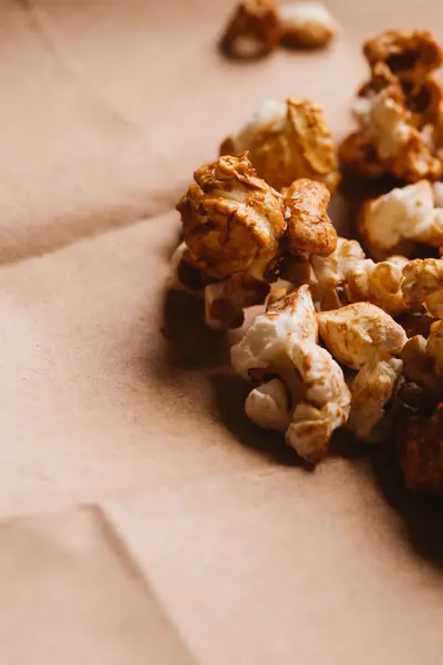 Sladký karamelový popcorn close-up na lehký papír — Stock fotografie