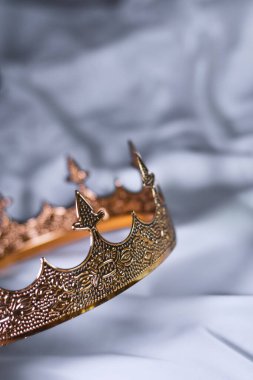 Beyaz saten arka planda altın taç