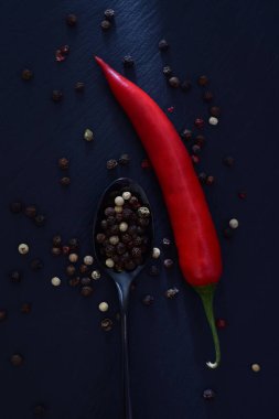 Taze baharatlar - kırmızı biber ve karışık siyah, beyaz ve kırmızı biberli kaşık.