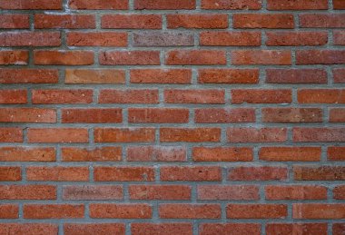 Telaffuz edilmiş dokusu olan kırmızı tuğlalı bir duvar. Fotoğraf, tasarım ve grafik projeleri için arka plan olarak mükemmel.