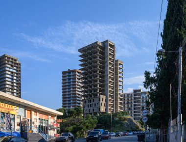 Tiflis, Gürcistan 'daki Saburtalo bölgesindeki modern yüksek binalar. Panoramik şehir manzarası ve mavi gökyüzünün altında yoğun şehir evleri.