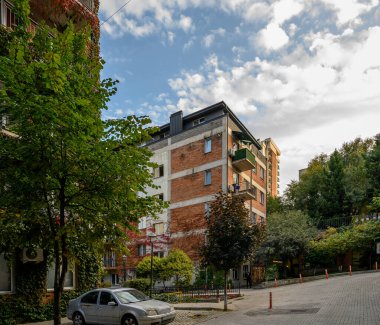 Saburtalo, Tiflis 'teki kırmızı tuğlalı evler ön cephelere tırmanan asmalarla süslenmiş. Şehir mimarisi yeşillikle uyumludur..