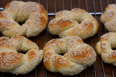 Lezzetli ev yapımı Türk simitleri, Ukraynalı bir kadının ahşap bir masanın üzerinde yaptığı susamlı ekmekler. Altın fırında mallar, Türkiye 'nin geleneksel ev ortamındaki tadı.