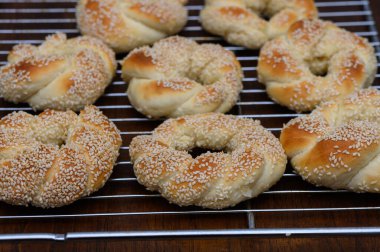 Kırsal ahşap bir masada susam tohumlarıyla kaplı gevrek altın Türk simit. Geleneksel Türk hamur işleri çoğunlukla kahvaltıda veya sokak yemeği olarak sunuluyor.