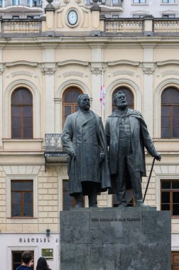 Tsereteli ve Chavchavadze 'nin Tiflis şehir merkezindeki gerçekçi bronz heykeli, yeşillik, popüler kent simgesi ve turist fotoğraflarıyla çevrili..
