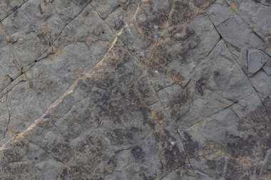 Doğal desenleri, dokuları ve tasarım, mimari ve açık hava projeleri için kaba detayları vurgulayan taş yüzeyinin makro çekimi.