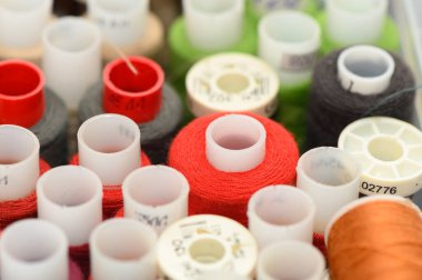 Dizayn, hobi ve tekstil kavramları için iplikleri nazik tonlarda dikmenin yumuşak odaklı makro arkaplanı.