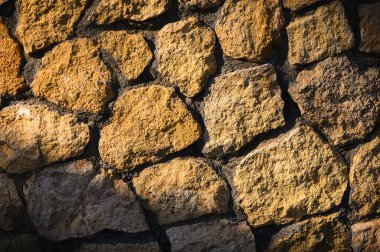 Güneş ışığı altında pürüzsüz, açık gri taş duvar, doğal dokuyu vurguluyor. Modern tasarım, web siteleri ve reklam tasarımları için ideal.