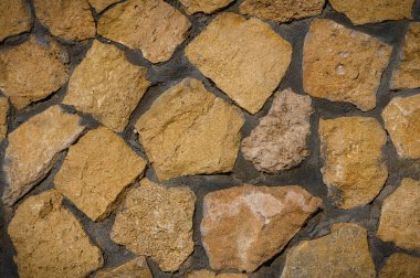 Güneş ışığı altında düzensiz doğal dokusu olan vahşi bir taş ustası. Seyahat ve mimari temalar için mükemmel.