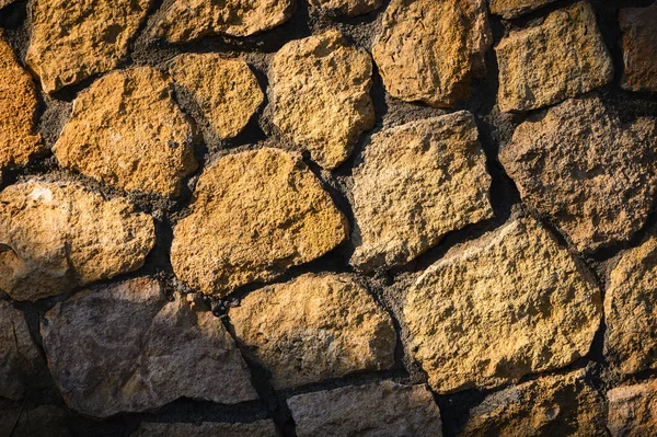 Güneş ışığı altında pürüzsüz, açık gri taş duvar, doğal dokuyu vurguluyor. Modern tasarım, web siteleri ve reklam tasarımları için ideal.