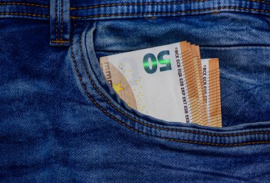 Kot pantolonun cebinde 50 Euro. Hisse fotoğrafçılığı ve kişisel finans illüstrasyonları için cep, finans ve para konsepti.