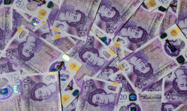 Masaya saçılmış 20 tane GBP notu var. Hisse senedi ve kişisel finans fotoğrafçılığı için nakit, para ve finans kavramı.