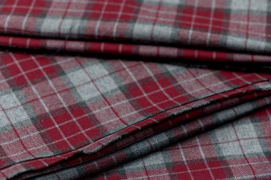 Klasik İskoç kontrol desenli ve detaylı desenli kırmızı yün kumaşın yakın çekimi.