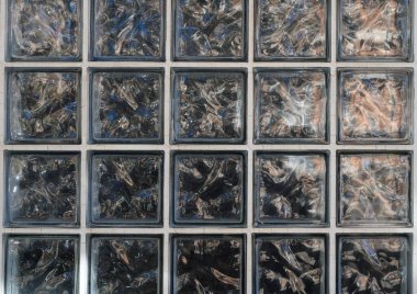 Geometrik desenli şeffaf cam bloklar ışık yansımaları ile soyut bir arkaplan oluşturur.