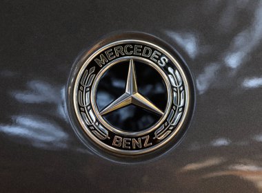 Tiflis, Georgia11,06.2025 koyu renk araba kaputundaki gümüş Mercedes-Benz amblemini kapat. Otomotiv fotoğrafçılığı ve tasarım için mükemmel.