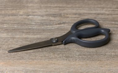 Sağlam çelik makas solmuş ahşap masada yatar. Sert ahşap doku ve havalı metal ev tarifleri ve bloglar için özgün bir arka plan oluşturur