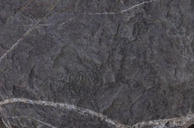 Düzensizlikleri, çatlakları ve doğal desenleri olan bir makro taş. Gri-kahverengi tonlar ve kabataslak rahatlama, eko projeleri ve minimalist kompozisyonlar için otantik bir zemin oluşturur.