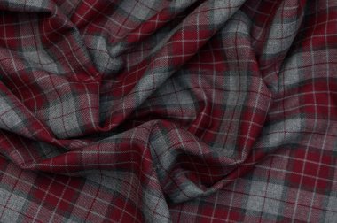 Mavi, beyaz ve kırmızı gölgeli, rahatlamış çizgilerle yakın plan tartan. Yoğun dokuma ve kabataslak yüzey, aksesuarlar ve tasarım projeleri için otantik bir arkaplan oluşturur.