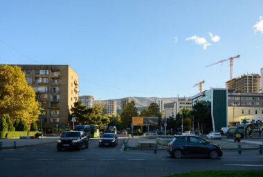 Tiflis, Georgia11,06.2025 Saburtalo 'daki uzun cam ve beton kuleli yeni yerleşim tesislerinin panoramik manzarası. Yeşil tepeler ve açık gökyüzü ilçenin kentsel büyümesini vurguluyor