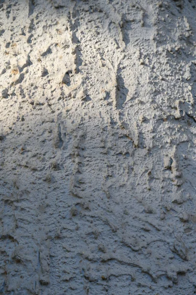 Sert dokusu, küçük gözenekleri ve hafif çatlakları olan beton duvarın makro görüntüsü. Nötr gri ton ve mat yüzeyi modern tasarım ve kentsel bileşimler için çok yönlü bir arkaplan oluşturur