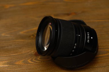 Tiflis, Gürcistan 11.09.2025 Stüdyo fotoğrafı Nikon 24-70 mm f4 S zoom mercek sabit açıklık ve hava durumu mührü ile ahşap masa. Metal montaj, oymalı işaretler ve ahşap tahıl katı bir zemin oluşturur. 