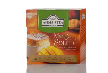 Tiflis, Gürcistan 11.09.2025 Ahmad Tea Mango Sufle kutusuna yakın plan beyaz arka plan. Mango ve yeşil aksanlı paketler yeşil çay reklamları için tropikal lezzeti vurgular.