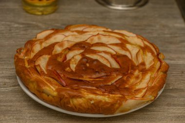 Rachian tahtasında yeni pişmiş elmalı turtanın stüdyo çekimi. Yumuşak ışık, buhar ve doğal tonlar Rachian tatlıları ve geleneksel sonbahar pişirmesi için otantik zemin oluşturur..