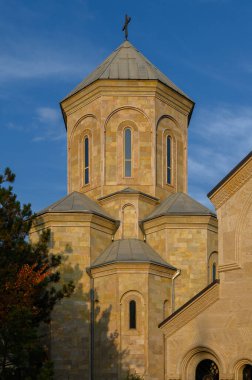 Açık gökyüzüne karşı Gürcistan Ortodoks Kilisesi manzarası. Taş kubbeler, haçlar ve karmaşık süsler kültürel miras ve ruhsal turizm reklamları için olağanüstü işçiliğin altını çiziyor.