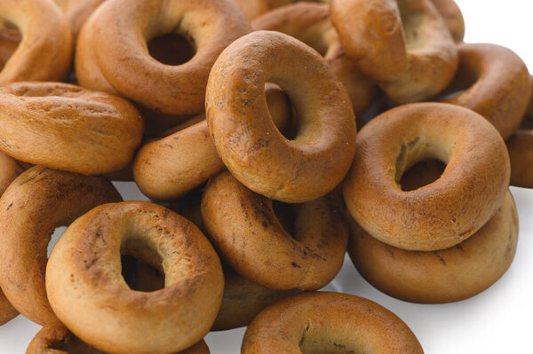 Detailed close-up of a heap of traditional East Slavic ring-shaped bread pastries known as sushki. Classic dry bakery product for tea drinking, showing texture and shape.