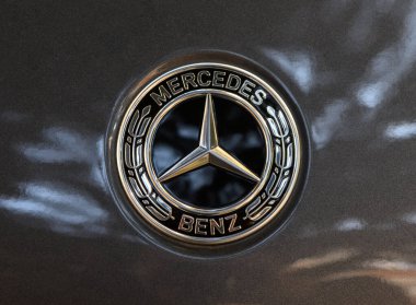 Tiflis, Georgia11,06.2025 koyu renk araba kaputundaki gümüş Mercedes-Benz amblemini kapat. Otomotiv fotoğrafçılığı ve tasarım için mükemmel.