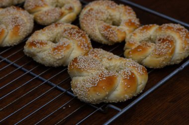 Ukraynalı bir kadın tarafından evde yapılmış taze Türk simitleri. Beyaz arka planda altın pişmiş mallar, mutfak fotoğrafçılığı için mükemmel..