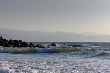Akdeniz 'in köpüklü yaz dalgaları Kıbrıs' ın kumlu sahillerine çarpıyor ve deniz kenarında dinlenme ve tatilin özünü yakalıyor.
