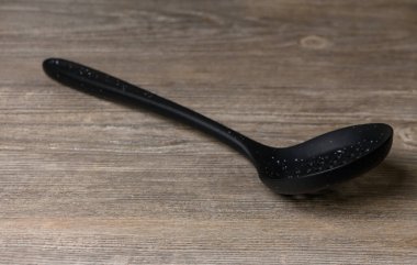 Kaypak ahşap mutfak masasında yatıyor. Mutfak gereçleri doğal ışık altında, yakın çekim. Yemek fotoğrafçılığı, mutfak tasarımı ve reklamcılık için uygun minimalist kompozisyon.