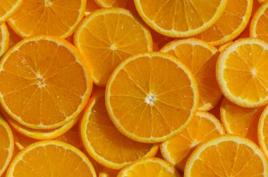 Portakallar dilimlere ayrılır ve masaya dizilir. Parlak bir yemek arka planı oluşturur..