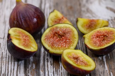 Beyaz bir zemin üzerine yerleştirilmiş olgun mor bir incir, mutfak ve doğal temalar için dokusunu vurguluyor..