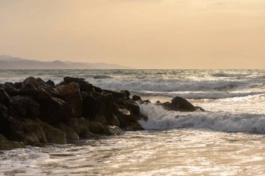 Gün batımında Kıbrıs sahillerinde hafif dalgalar çakıyor