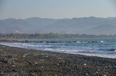 Kıbrıs 'taki Morphou Körfezi' nin kumlu sahili, parlak bir yaz gününde Akdeniz ufka kadar uzanıyor.