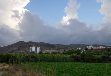 Kıbrıs 'taki dağların manzaralı zeminine karşı Akdeniz' deki bir konut kompleksinde modern beyaz evler kuruldu.