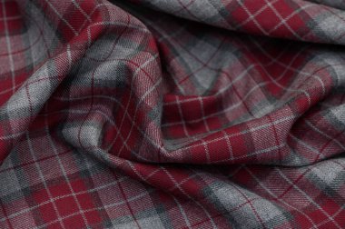 Koyu yeşil, kırmızı ve siyah tonlarda iplik dokuması olan klasik İskoç kumaşı. Yün dokusu ve net kontroller moda koleksiyonları ve iç mekanlar için geleneksel bir arkaplan oluşturur.