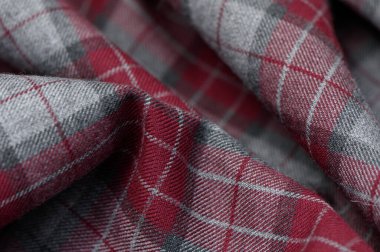 Kırmızı, siyah ve beyaz tonlarda birbirine zıt çizgilerle İskoç tartanı. Yoğun yün dokuma ve rahatlamış doku moda ve geleneksel projeler için anlamlı bir arkaplan oluşturur.