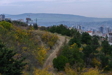Tiflis 'in Saburtalo bölgesindeki modern yerleşim yerlerinin dağ manzarası ve arka planda Kafkas dağları var..