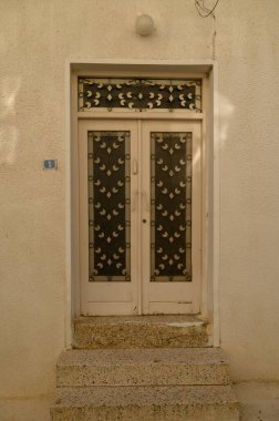Kıbrıs 'ta geleneksel bir evde kırsal dokusu olan eskimiş beyaz ahşap kapı, Akdeniz cazibesini çağrıştırıyor.