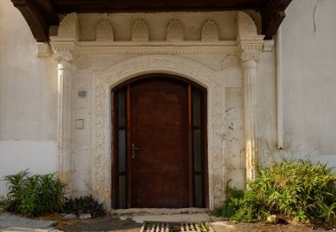 Kıbrıs 'ta beyaz duvarları olan bir evin eski kemerli taş kapısı, geleneksel Akdeniz mimarisini yansıtıyor.