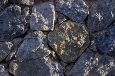 Doğal taştan duvar dokusunun yakın çekimi. Tasarım, mimari, inşaat, Akdeniz tarzı ve dekoratif yüzey için kırsal arkaplan kavramı