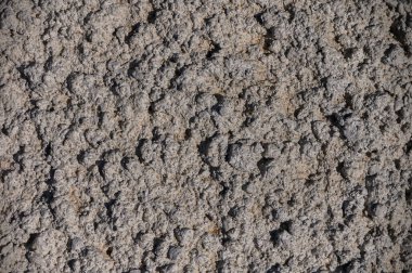 Doğal dokuları olan, mimari, tasarım ve doğa temalı stok fotoğrafçılığı için ideal engebeli taştan bir duvarın yakın çekimi. Doğal arka plan olarak taş duvar. Yüksek kalite fotoğraf