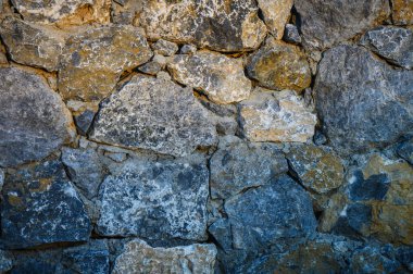 Kıbrıs 'ta doğal taştan yapılmış duvar. Doku ve doğal tonlarda. Ürün fotoğrafçılığı, makro çekimler ve tasarım projeleri için mükemmel bir arka plan..