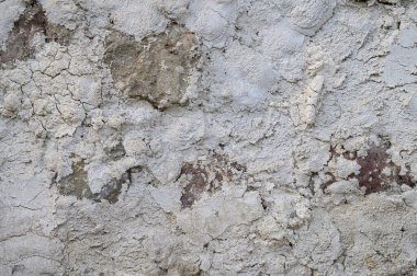 Çatlak, leke ve dengesiz doğal dokusu olan eski bir beton duvarın dikey yakın çekimi. Stok fotoğrafçılığı için mükemmel bir geçmiş..