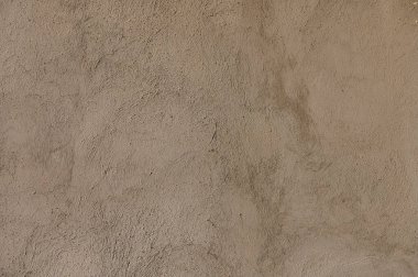 Güneş ışığı, kerpiç duvarlarında gölgeler oluşturur. Çöldeki el yapımı inşaatın güzelliğini vurgular..