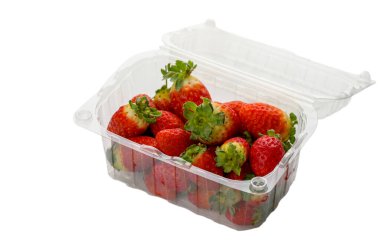 Olgun, kırmızı çilekler temiz beyaz arka planda şeffaf plastik kabın içinde düzgünce düzenlenmiş. Market ve yiyecek perakende tasviri için mükemmel..