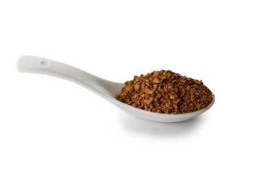 A white ceramic spoon filled with dark instant coffee granules, isolated on pure white background. The minimalist composition highlights the contrast between the spoon and coffee.